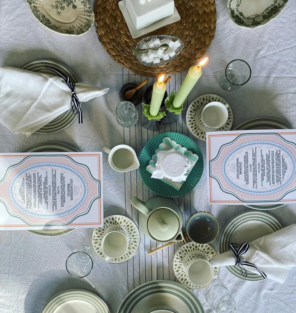 A dining table laid for an evening meal, with menus and candles